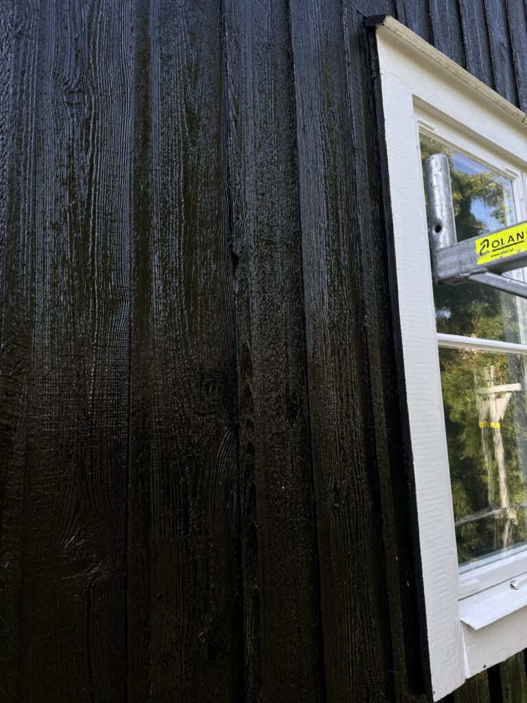 Närbild på fasad, tjärad