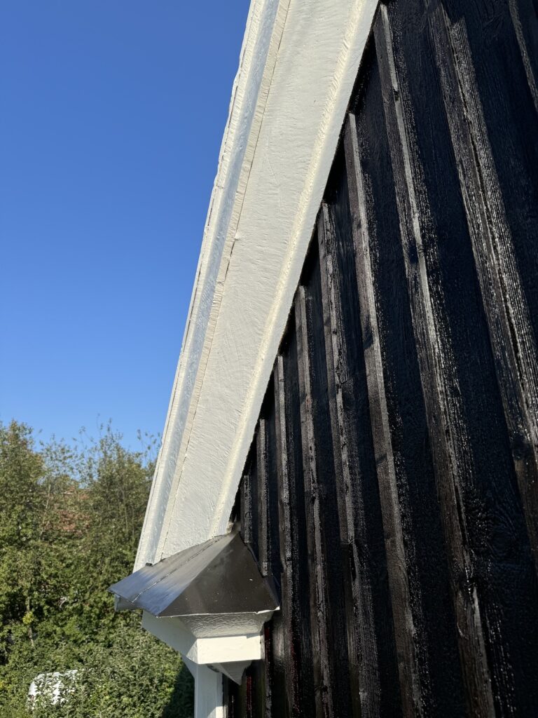 Närbild på fasad, tjärad